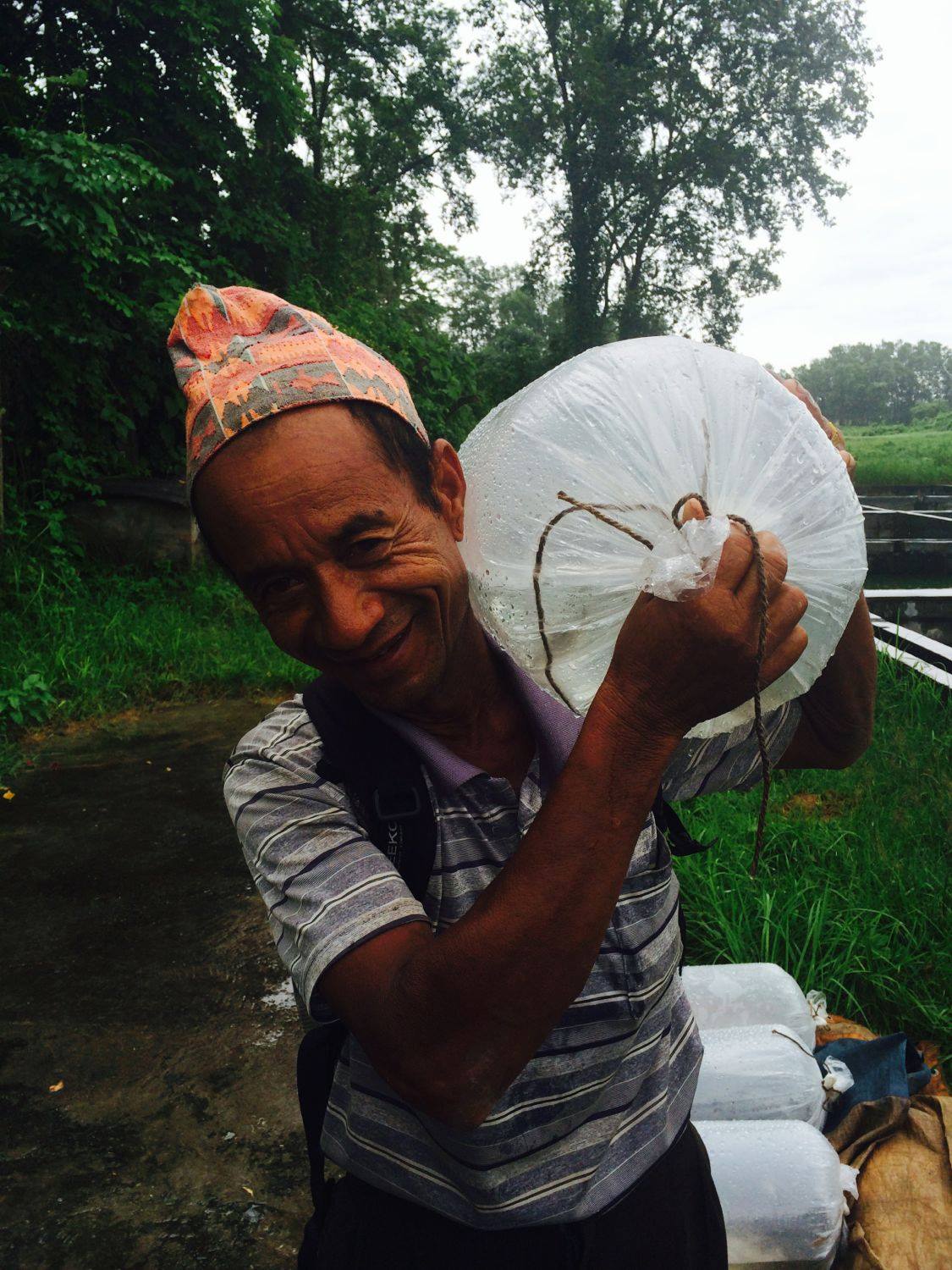 Portrait of a local community partner in a rural fish farming setting.
