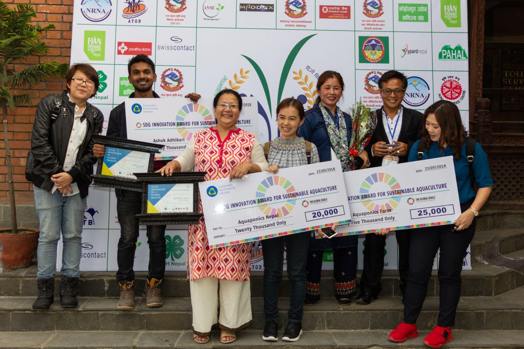 Award recipients and supporters pose with SDG Innovation Award checks and certificates.