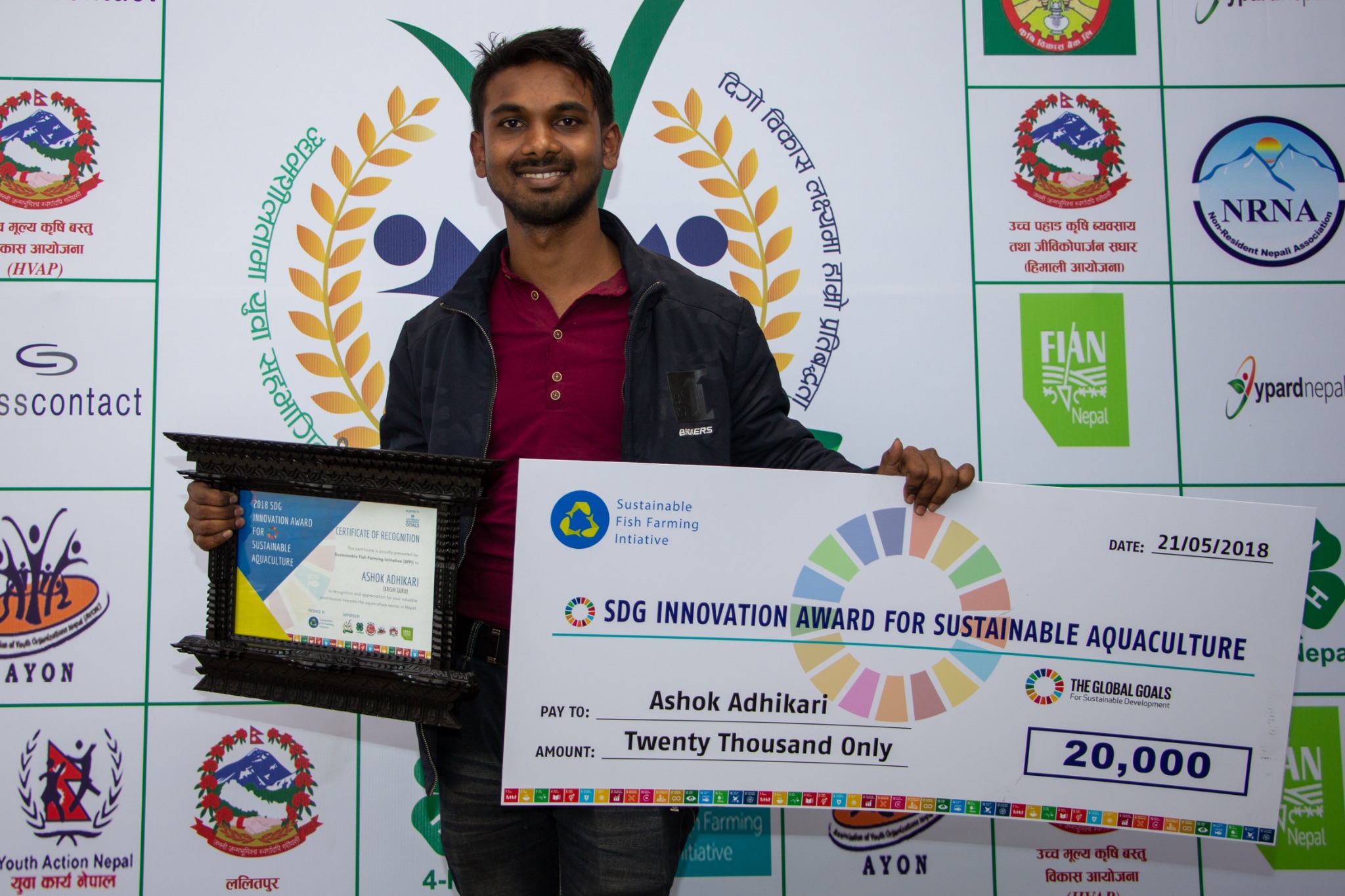Ashok Adhikari holds an SDG Innovation Award check and certificate.