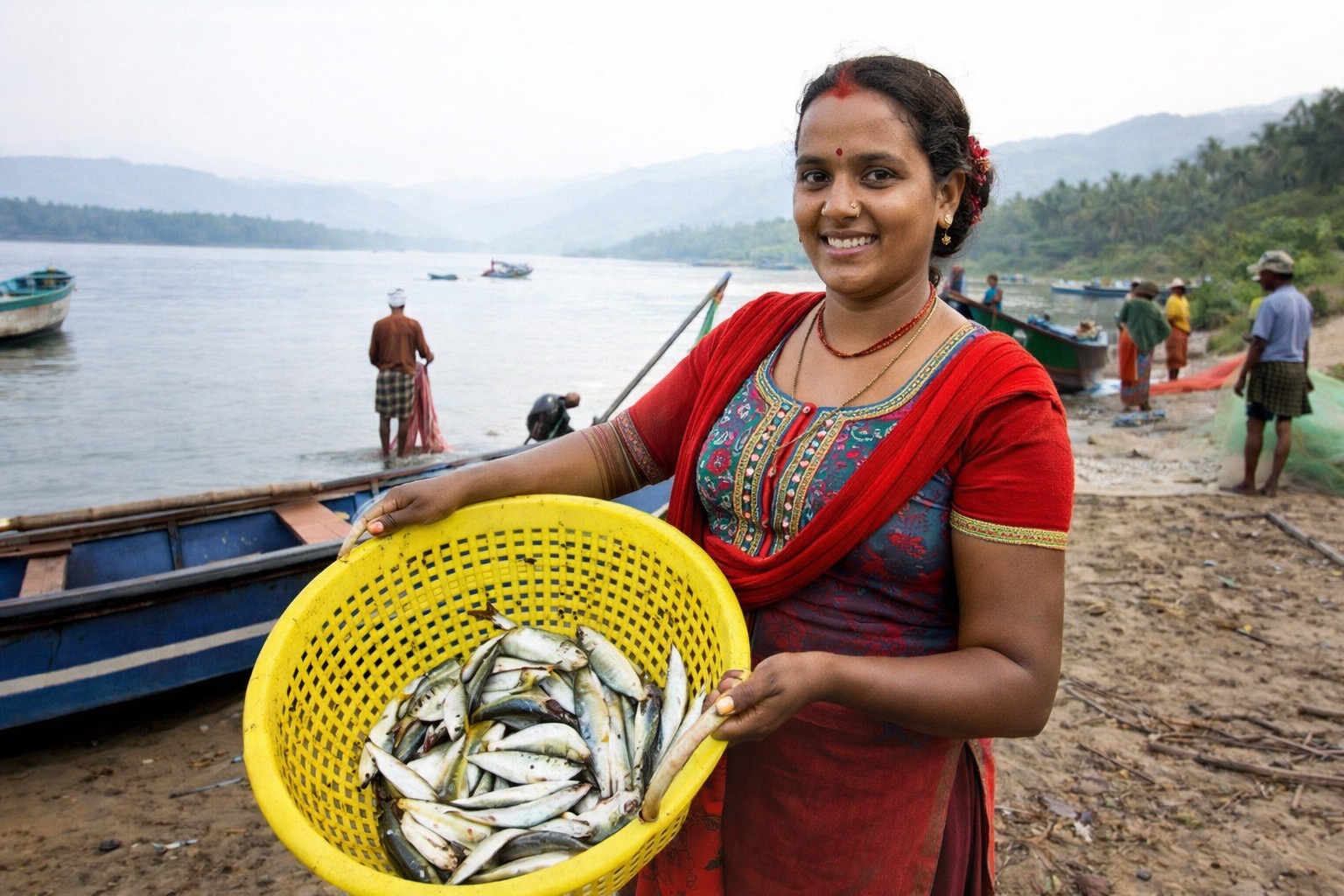 Sumnima holds a basket of fish on a riverbank in Chitwan, Nepal.